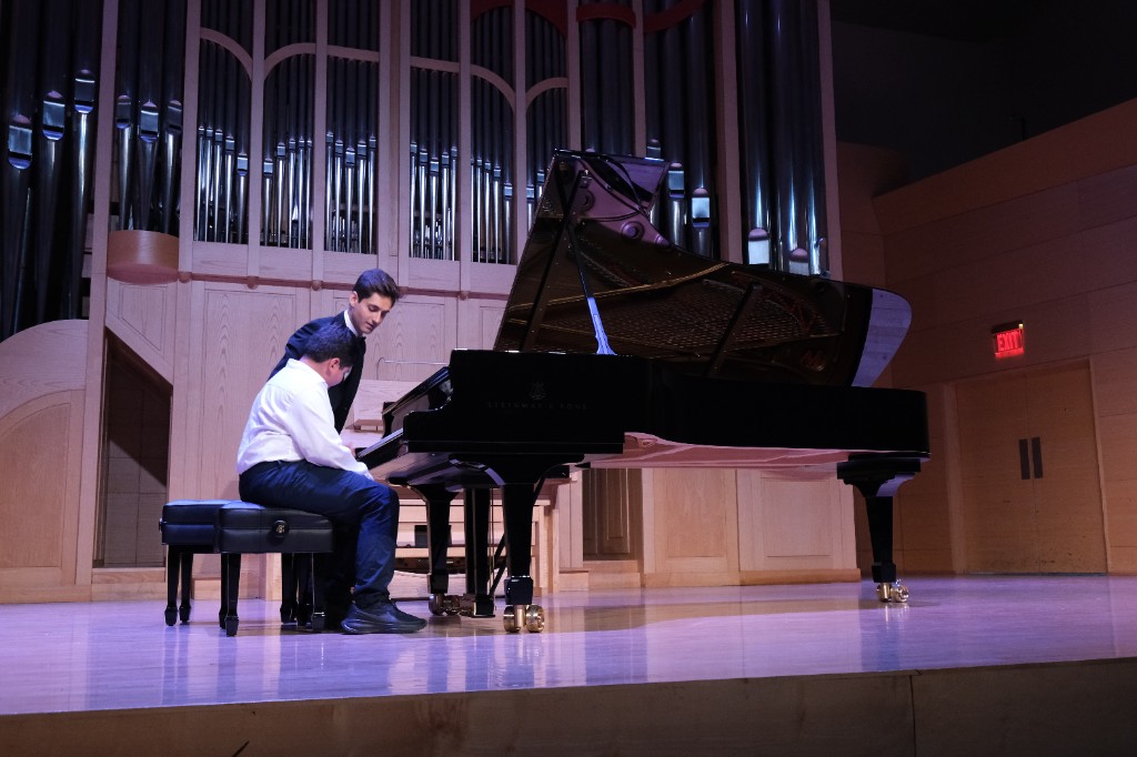 Artem Alexanian guiding a student at the piano on stage