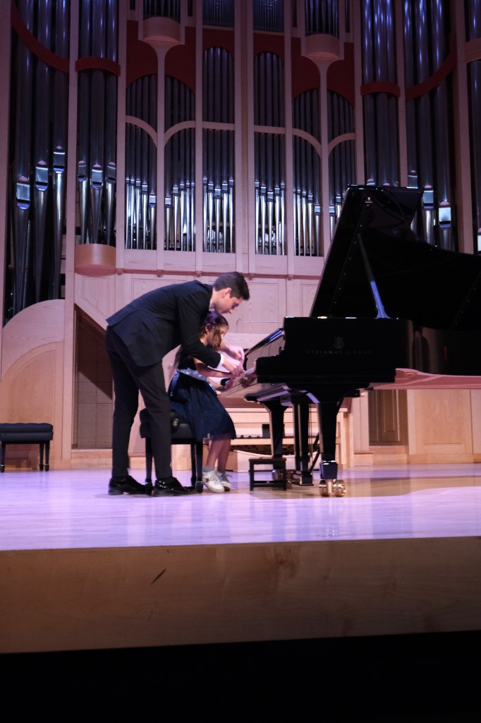 Artem Alexanian teaching a student at a Steinway grand piano with pipe organ backdrop
